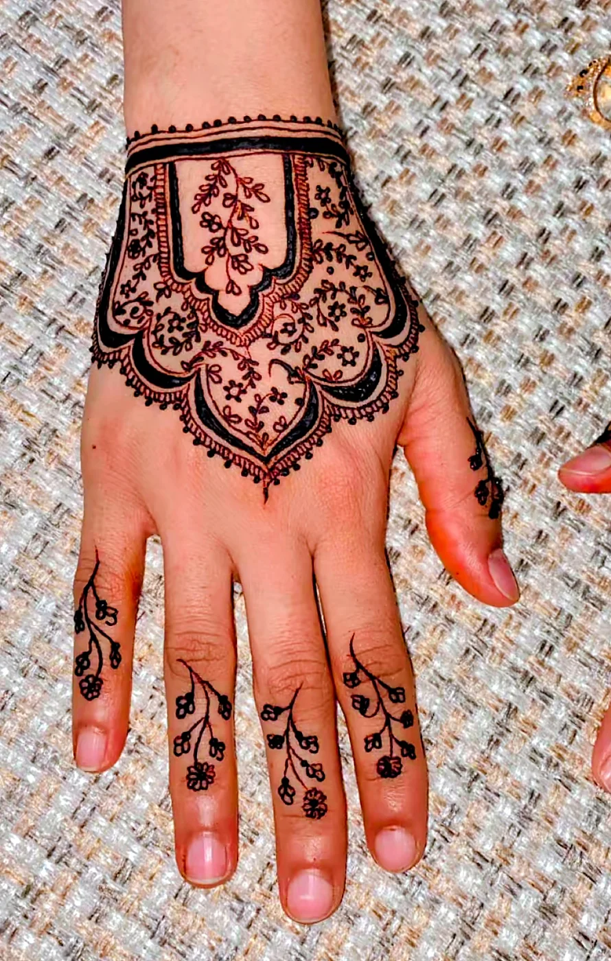 Mehndi design on the back of the hand at Glow Beauty Salon Kasur